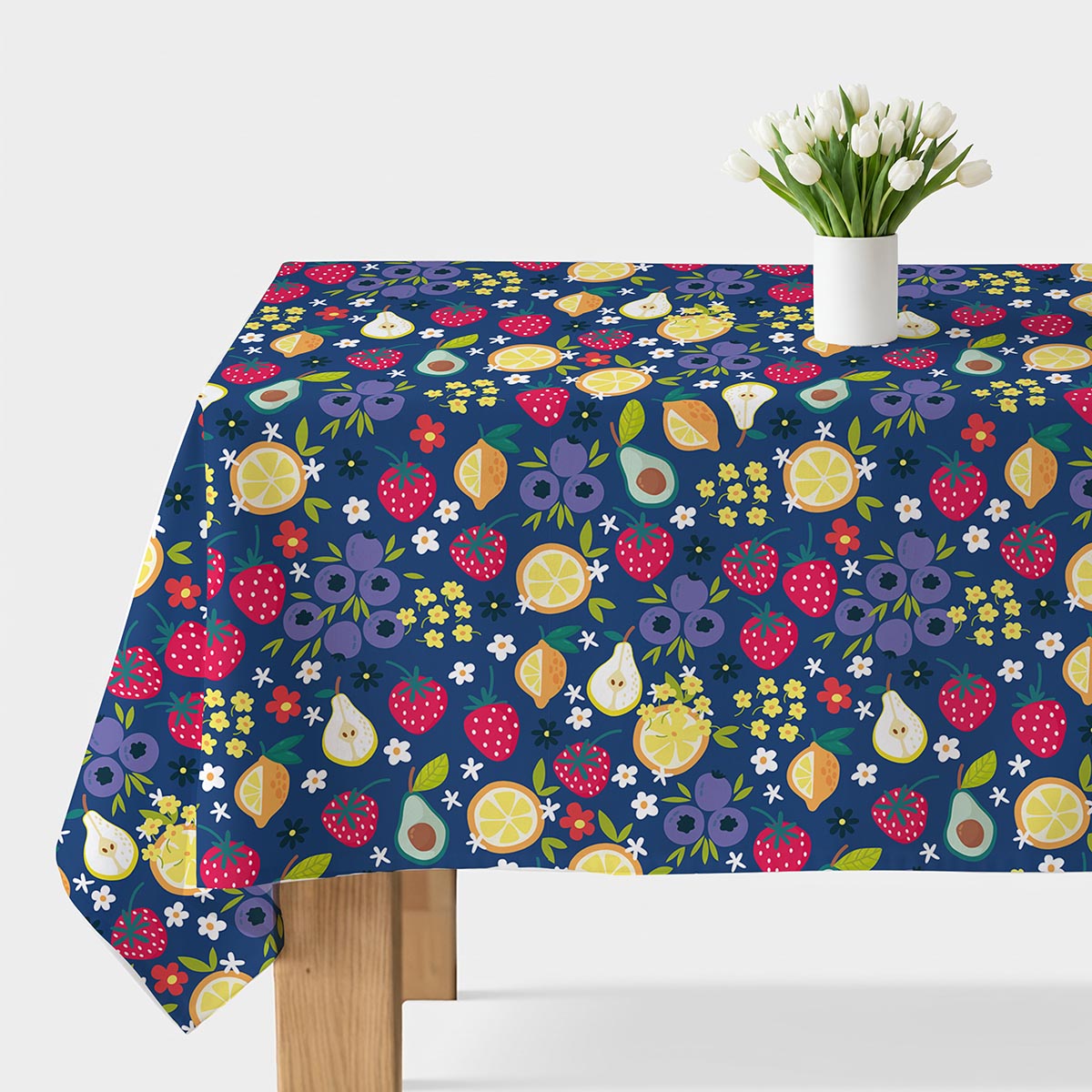 Obrus z owocowym wzorem na stole, widok z góry z białym wazonem z tulipanami