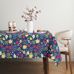 Detal obrusu z owocami i drobnymi kwiatkami przy białym wazonie z bawełnianymi gałązkami