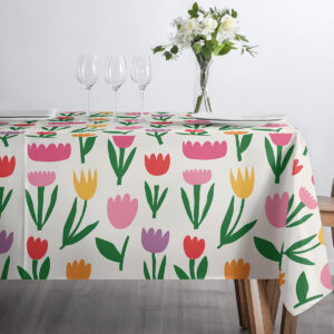 blat stołu z nakryciami, kieliszkami i obrusem w kolorowe tulipany