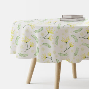 okrągły obrus na stole z motywem żółtych kwiatów i zielonych listków, widok z boku z książkami na stole