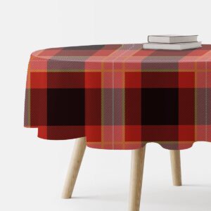 Okrągły obrus w czerwoną i czarną kratę na drewnianym stole, widok z boku