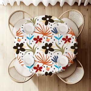 widok z góry na okrągły stół pokryty obrusie z rysunkowym motywem kwiatów