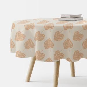 okrągły obrus z motywem liści ułożony na stole z książkami