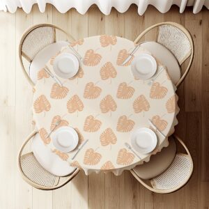 widok z góry na okrągły stół z obrusem w powtarzający się wzór liści i nakrycia