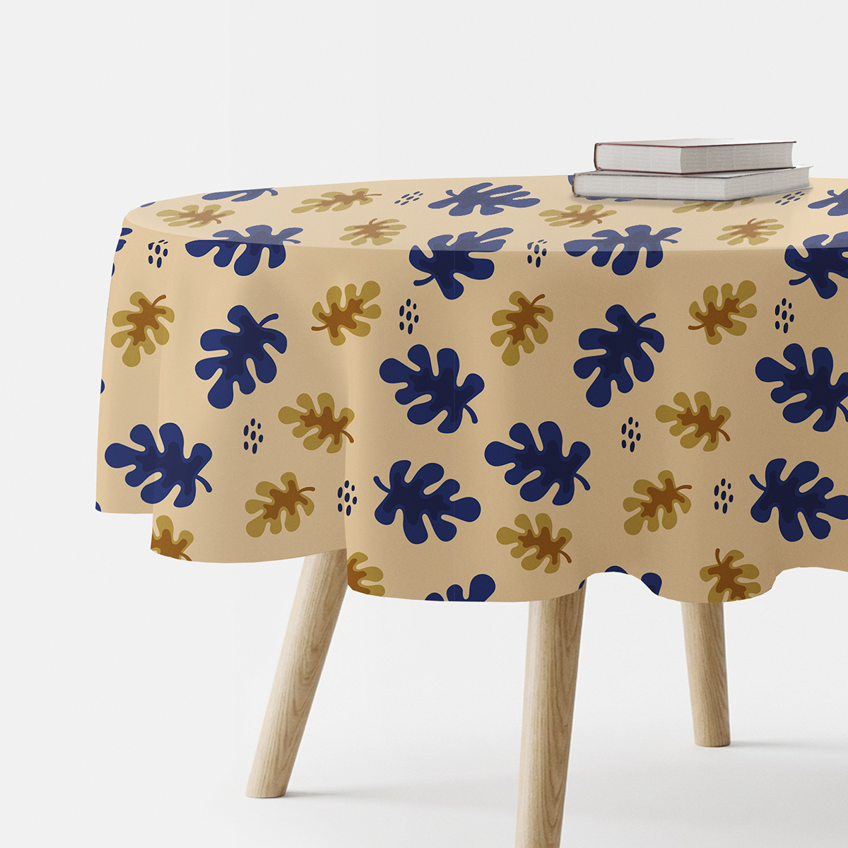 okrągły obrus na stole z wzorem granatowych i złotych liści, ujęcie z boku