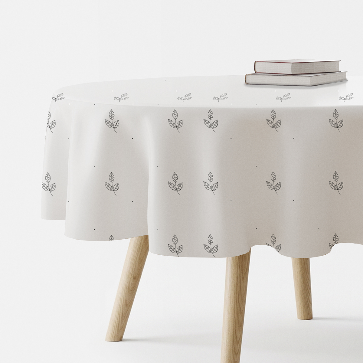 okrągły obrus na stole z delikatnym wzorem listków i drobnymi kropkami