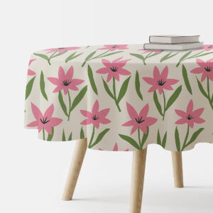 Okrągły obrus na stole z nadrukiem różowych kwiatów, ujęcie z boku z książkami na blacie