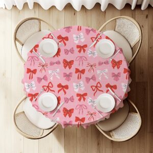 widok z góry na okrągły stół udekorowany obrusem z motywem kokardek i nakryciami