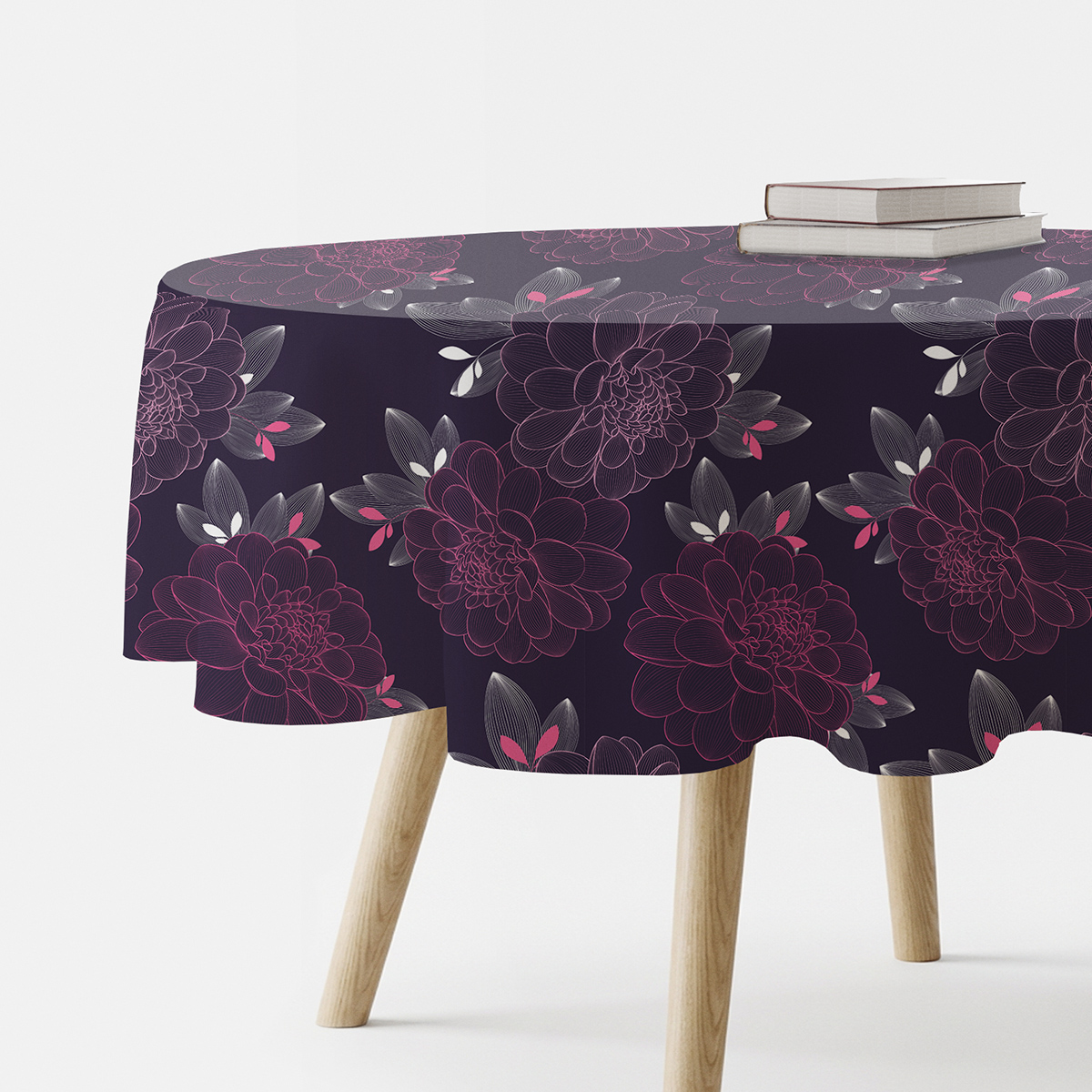 okrągły obrus z motywem kwiatowych konturów na granatowym tle ułożony na stole z książkami