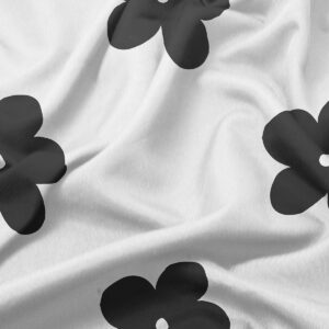 zbliżenie na fakturę tkaniny i czarny kwiatowy nadruk na jasnym tle