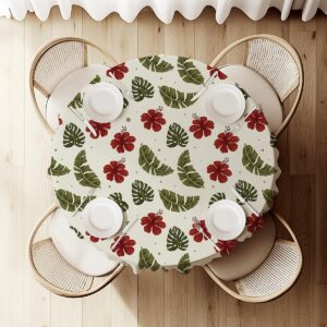 widok z góry na okrągły obrus z rozłożonym nakryciem i wzorem liści oraz hibiskusów