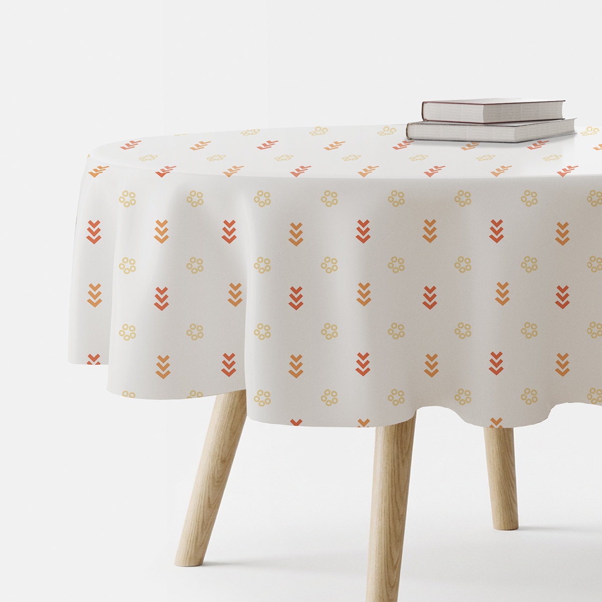 Obrus okrągły na drewnianym stole z wzorem małych kółeczek i strzałek w ciepłych odcieniach