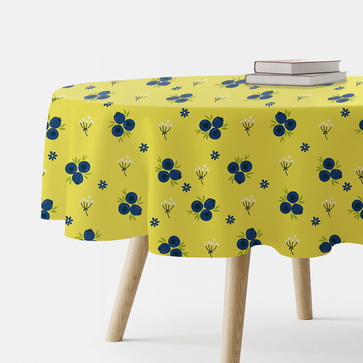 okrągły obrus na stole z motywem granatowych jagódek na cytrynowym tle