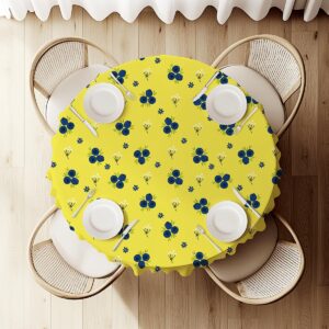 widok z góry na okrągły stół nakryty obrusem z jagódkami, ustawione nakrycia i sztućce