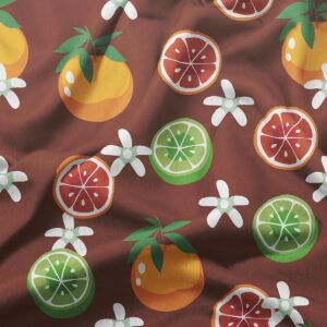 Zbliżenie na tkaninę z nadrukiem pomarańczy, plasterków limonki i białych kwiatów