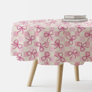 okrągły obrus na stole w pudrowej kratce z różowymi kokardkami widok z boku