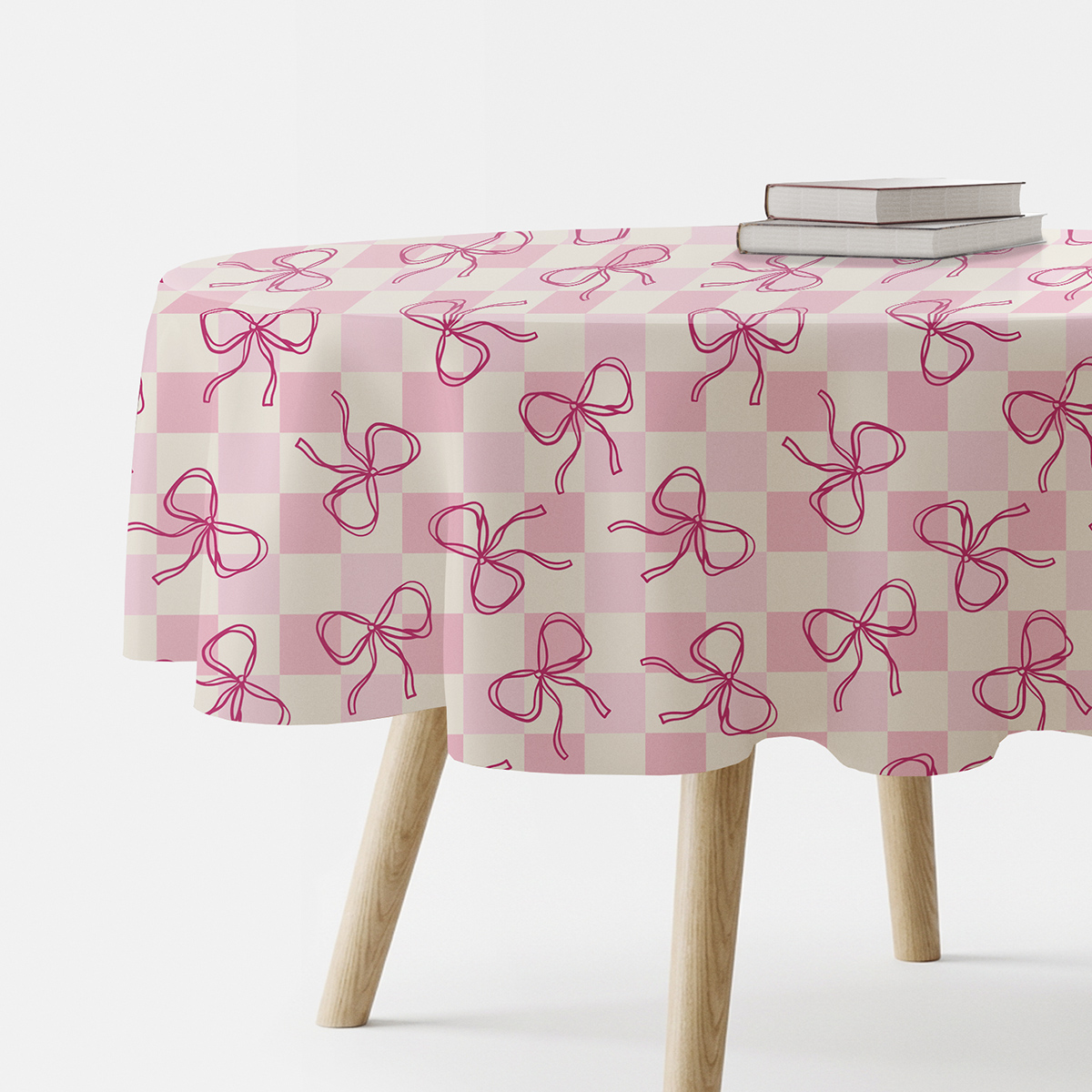 okrągły obrus na stole w pudrowej kratce z różowymi kokardkami widok z boku