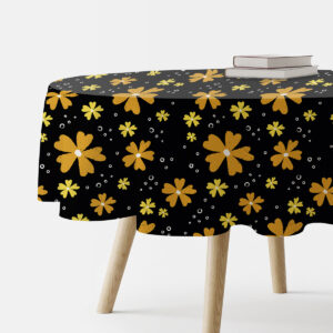 okrągły obrus na stole z czarnym tłem i żółtymi malowanymi kwiatami