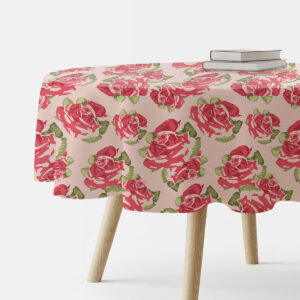 Okrągły obrus na stole z wzorem dużych malowanych róż na pudrowym tle