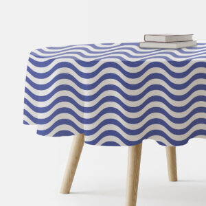 okrągły obrus na stole z niebiesko-białym falistym wzorem ze stosikiem książek