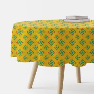 okrągły obrus z żółtym tłem i turkusowo-czerwonym folkowym wzorem na stole