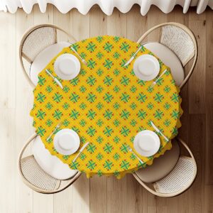 widok z góry na okrągły stół przykryty żółtym obrusem z geometrycznym folkowym wzorem