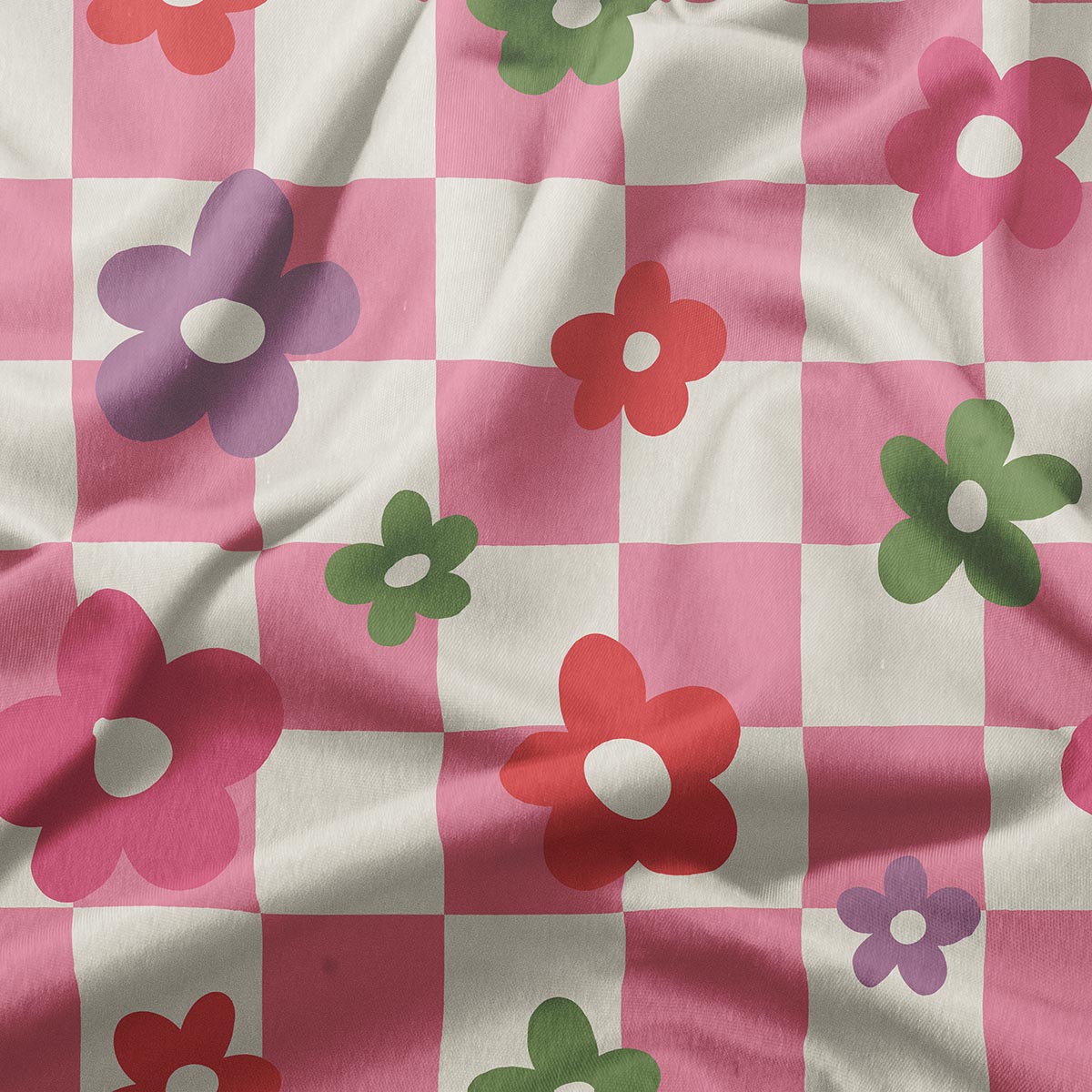 Zbliżenie na materiał z różowymi kwadratami i prostymi kwiatowymi motywami w zieleni, czerwieni i fiolecie