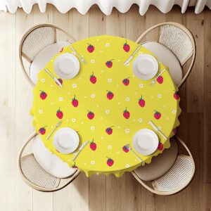 widok z góry na okrągły stół udekorowany obrusem w truskawki z ustawionymi talerzami