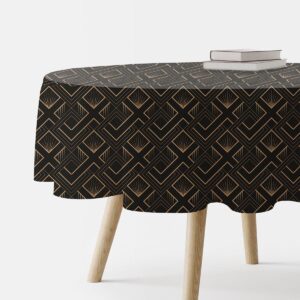 Okrągły obrus z czarnym tłem i geometrycznym złotym wzorem, ujęcie boczne pokazujące część blatu