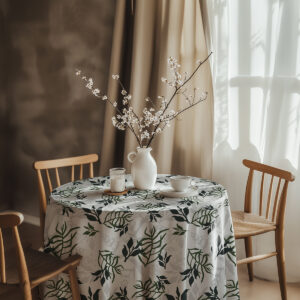 aranżacja stołu z wazonem z kwitnącymi gałązkami i filiżanką na obrusie w roślinny wzór