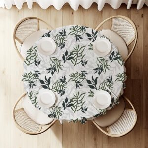 widok z góry na okrągły stół nakryty obrusem z liściastym deseniem i zastawą talerzy