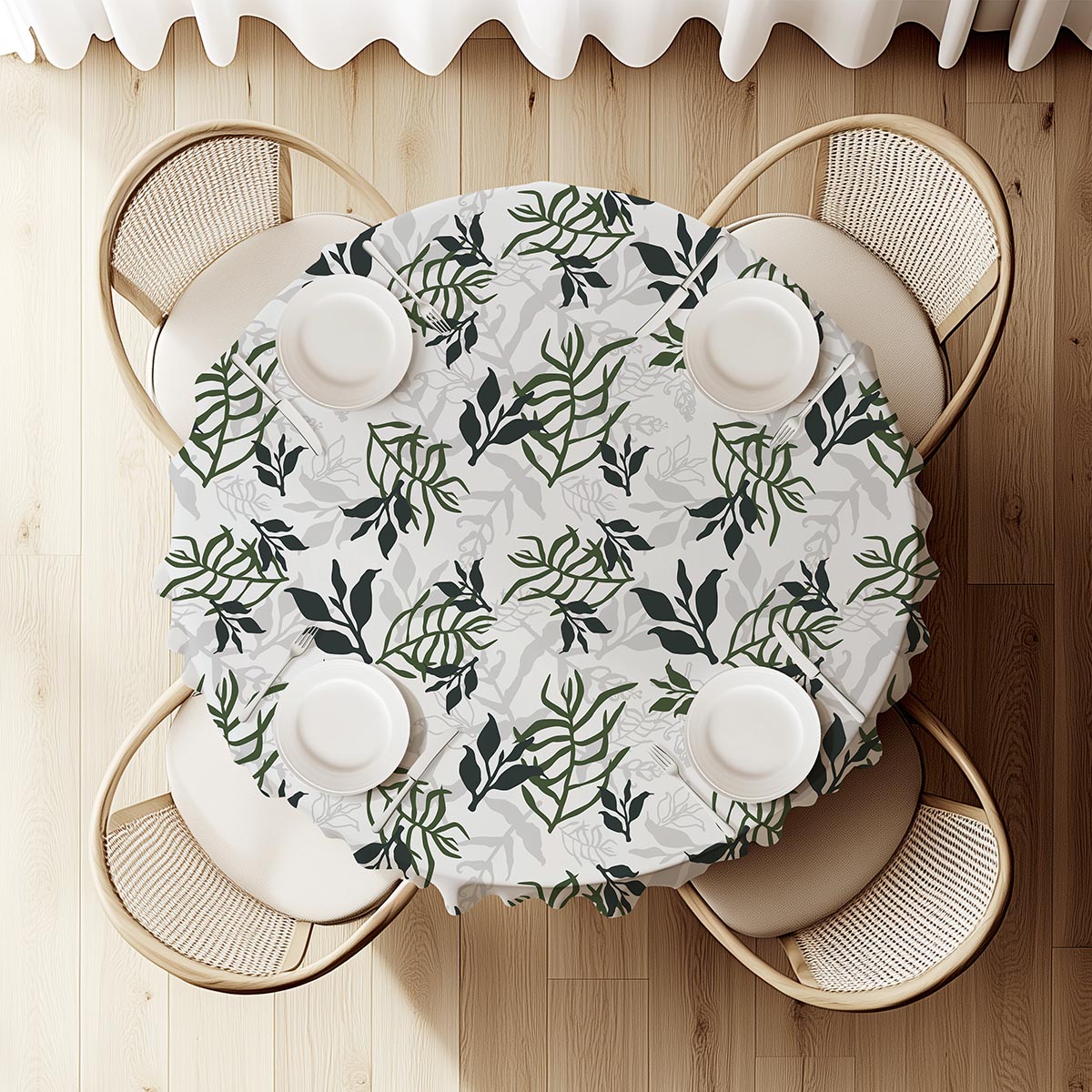 widok z góry na okrągły stół nakryty obrusem z liściastym deseniem i zastawą talerzy