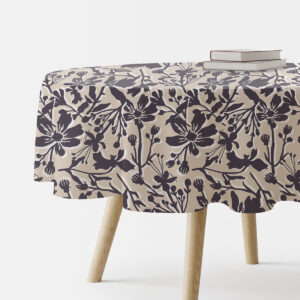 Okrągły obrus na stole z dużym kwiatowym motywem na beżowym tle