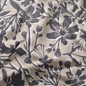 Zbliżenie na fakturę tkaniny i szczegóły grafitowych kwiatów z białymi konturami
