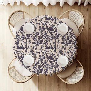 Widok z góry na okrągły stół z obrusem w kwiaty i ustawionymi talerzami