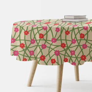 okrągły obrus na stole z beżowym tłem, zielonym motywem sieci i różowo-czerwonymi kwiatuszkami