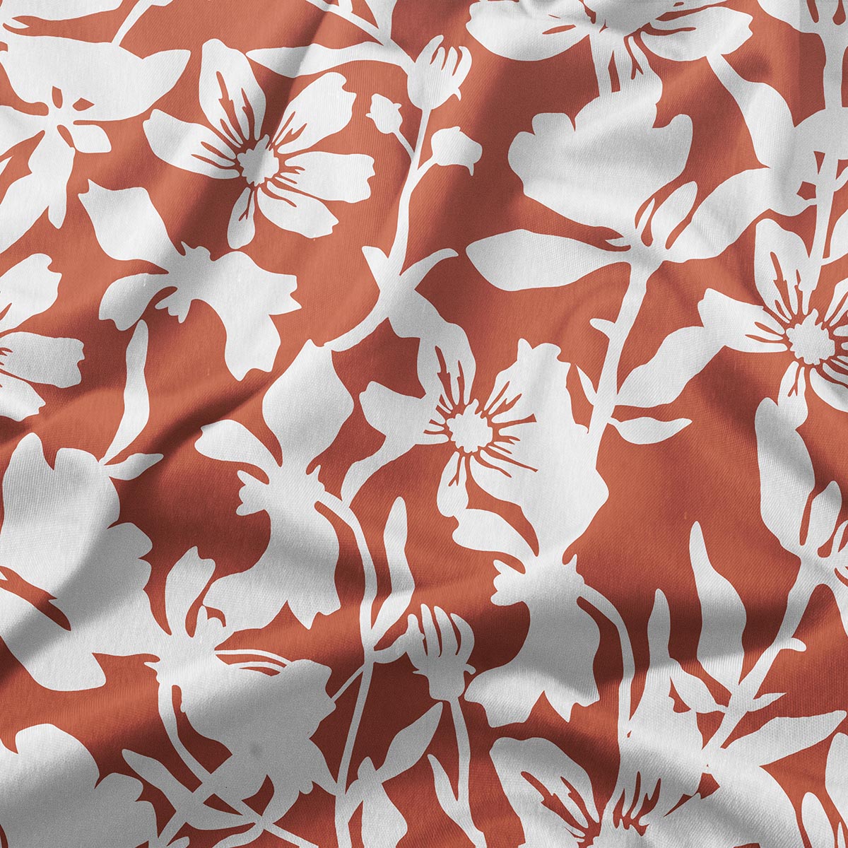 Zbliżenie na dekoracyjny biały motyw kwiatowy na ceglastym tle pokazujące fakturę tkaniny