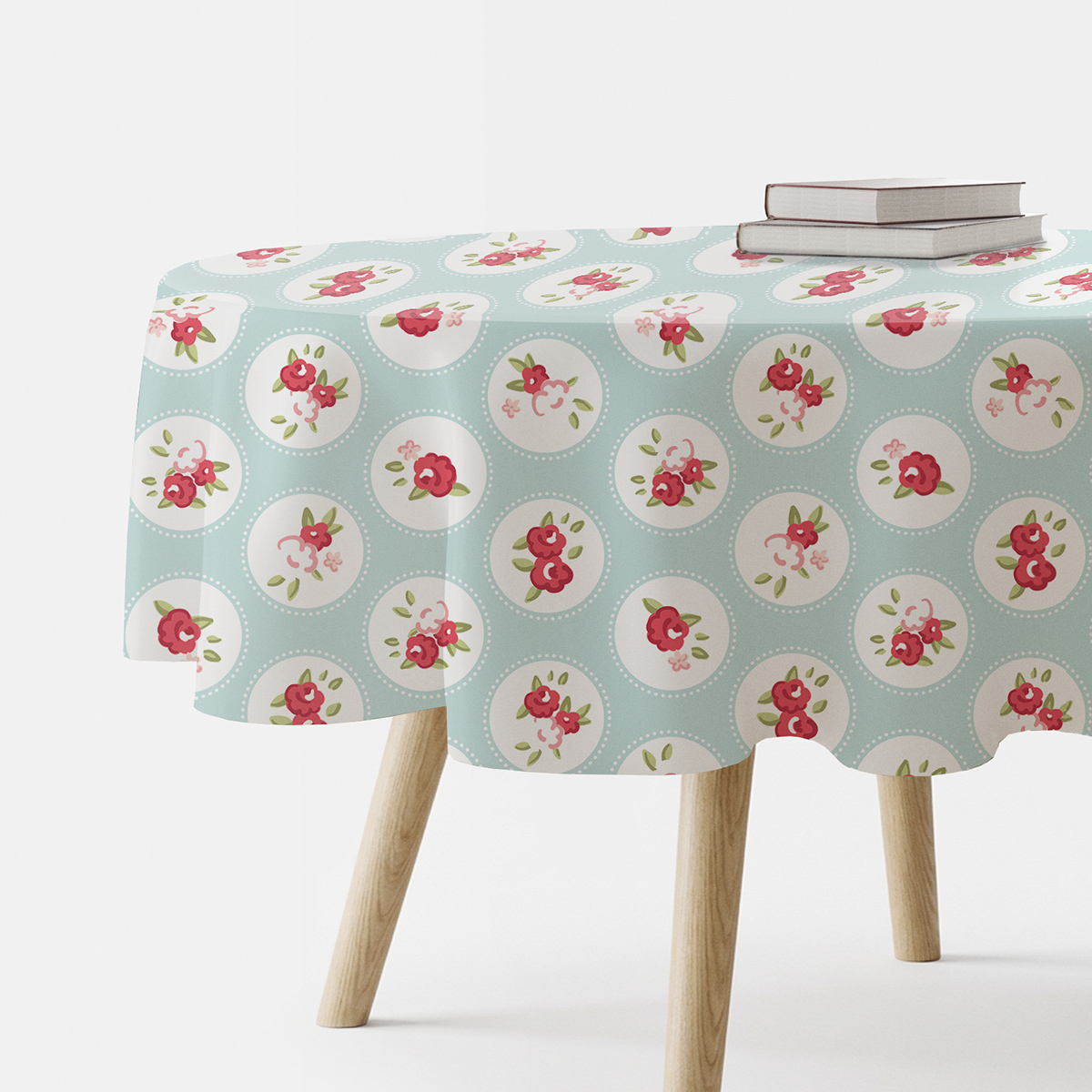 Okrągły obrus na stole w miętowym kolorze z różowymi bukiecikami w białych medalionach