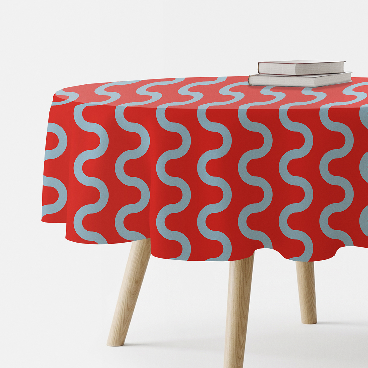 okrągły czerwony obrus z błękitnymi falami na stole, ujęcie boczne