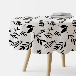 okrągły obrus z czarnym wzorem gałązek ułożony na stole