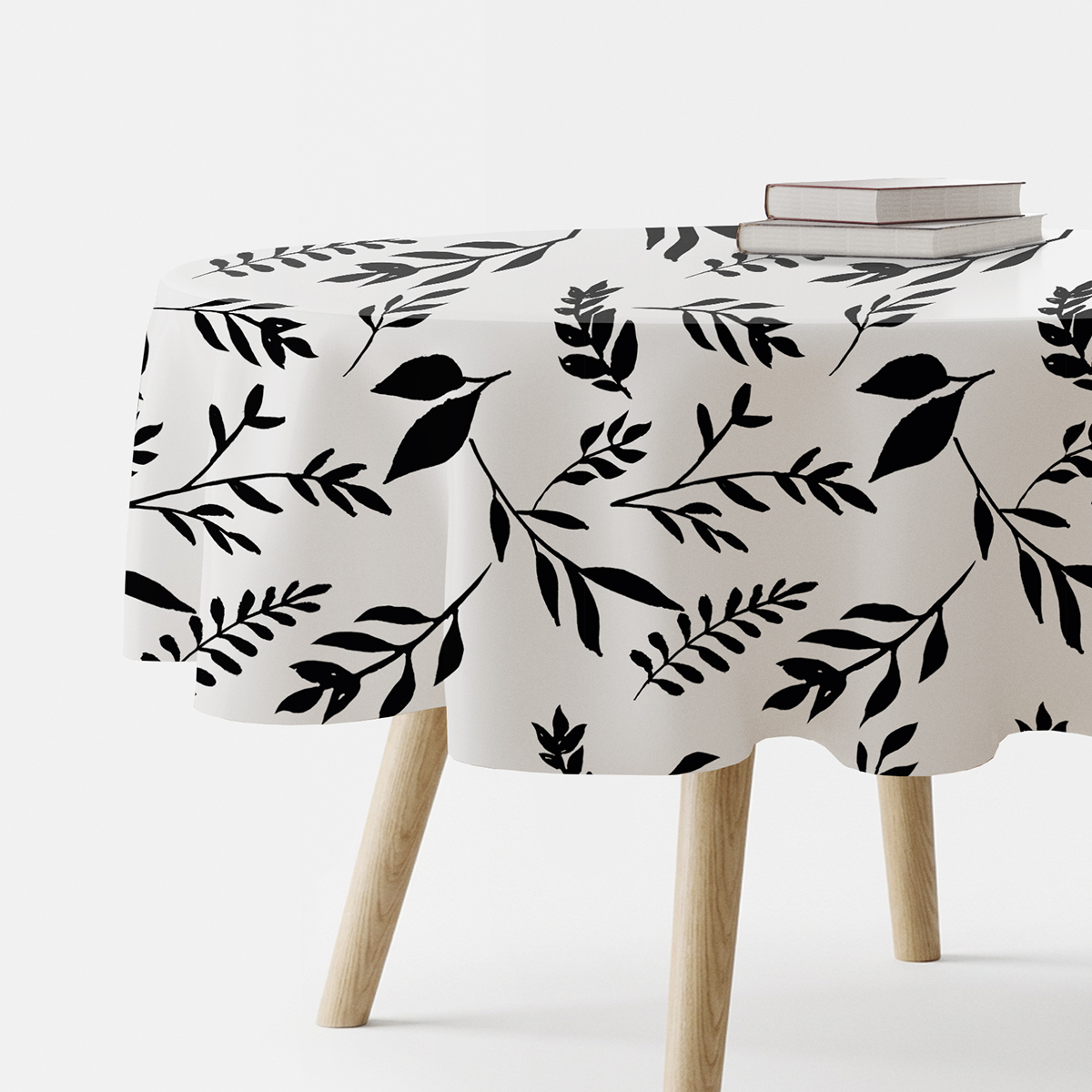 okrągły obrus z czarnym wzorem gałązek ułożony na stole