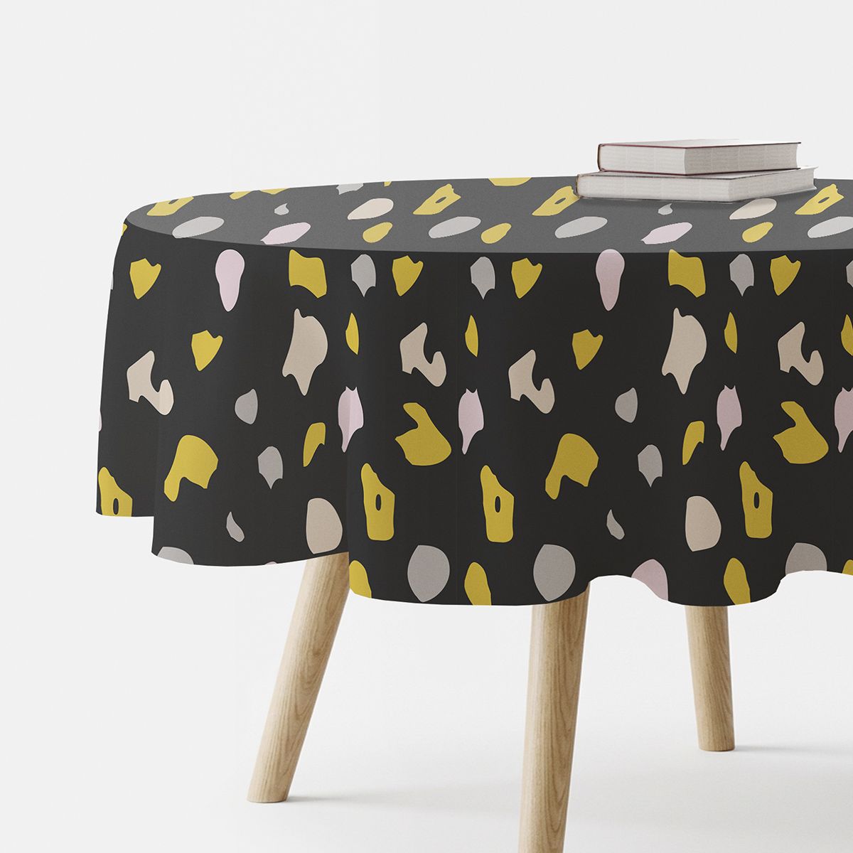 okrągły obrus na stole z widocznym grafitowym tłem i musztardowo-pudrowym wzorem terrazzo
