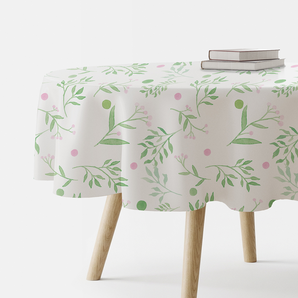 okrągły obrus na stole z akwarelowym wzorem zielonych gałązek i różowych kropek