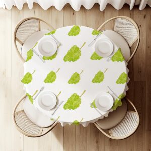 widok z góry na okrągły stół nakryty obrusem z motywem zielonych kiści winogron