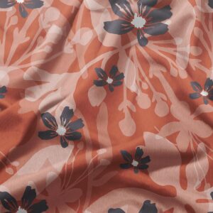 Zbliżenie tkaniny pokazujące pudrowo-różowe nakładki i granatowe kwiaty