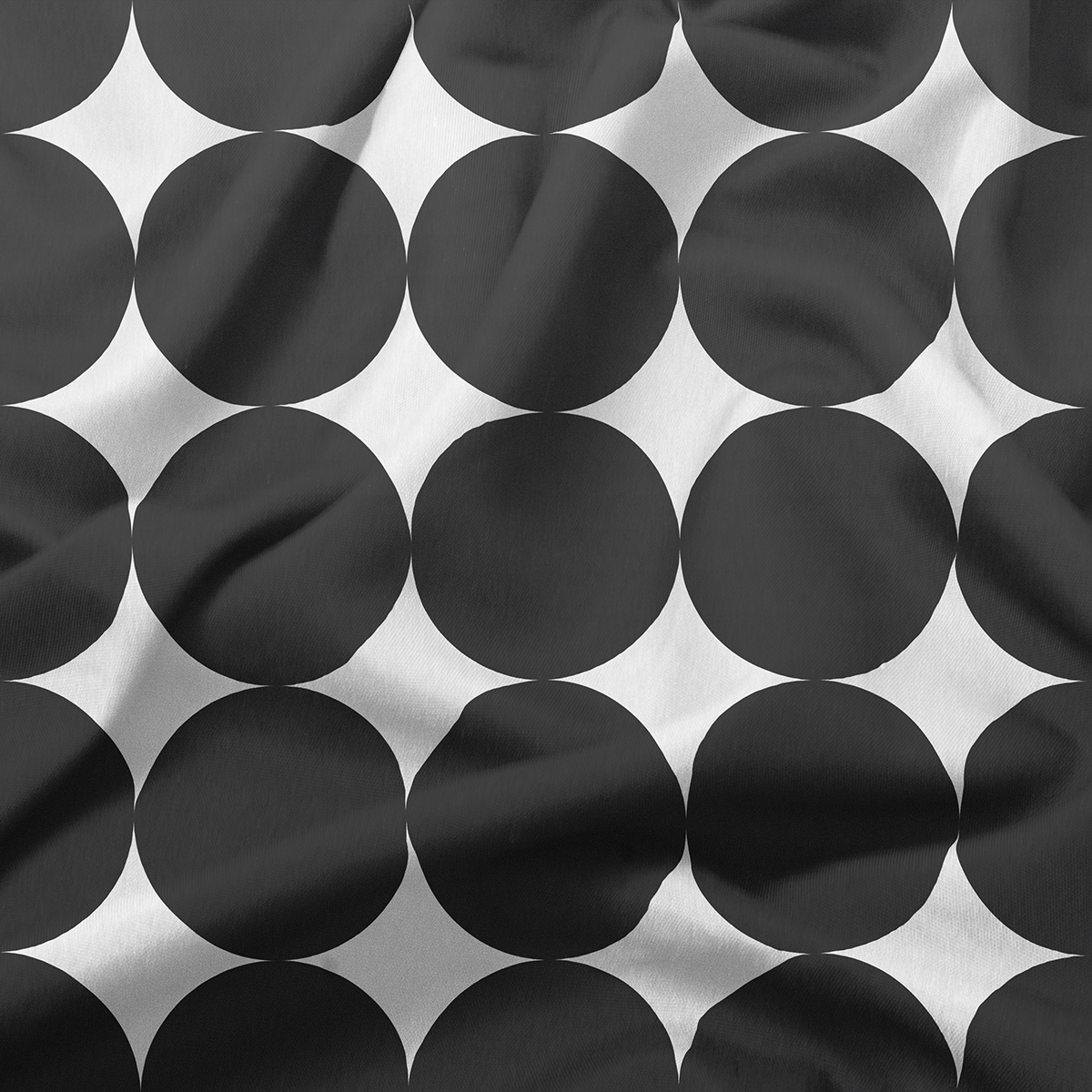zbliżenie na materiał i regularny wzór czarnych kółek na jasnym tle