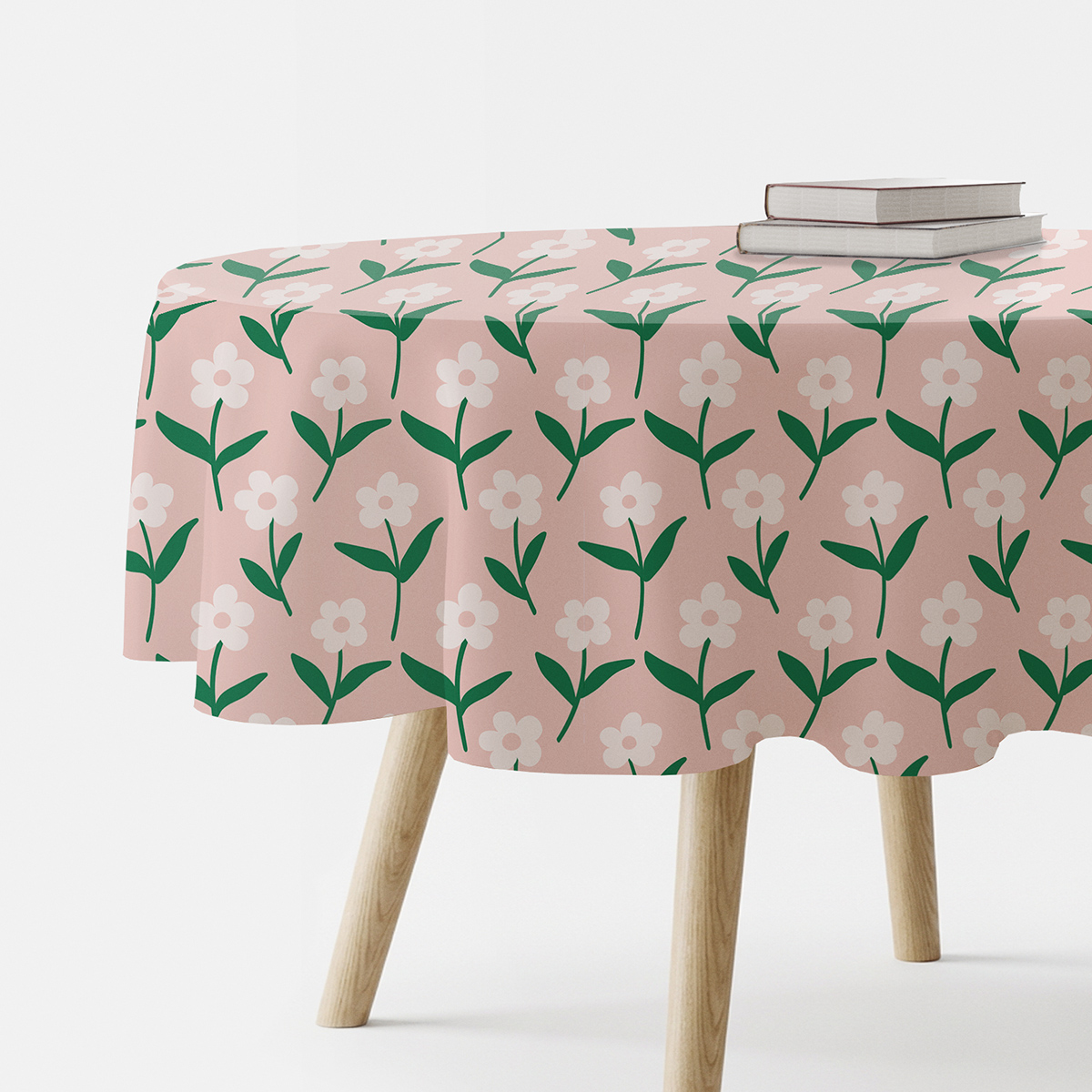 okrągły obrus na stole z różowym tłem i powtarzającym się wzorem białych stokrotek