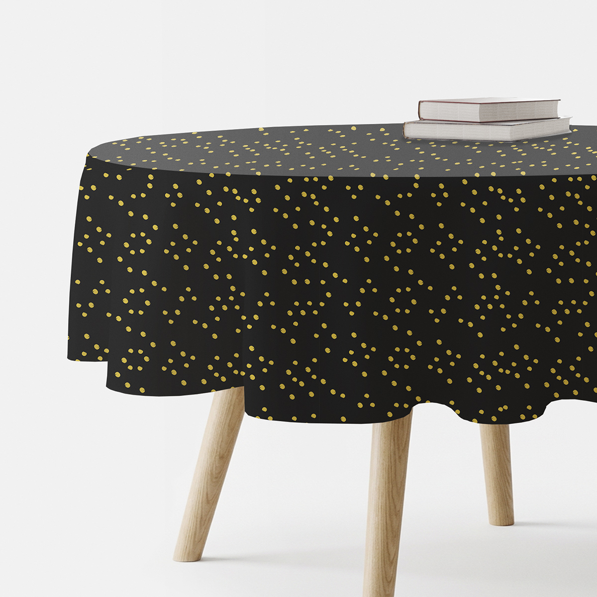 okrągły czarny obrus z drobnymi złotymi kropkami na stole