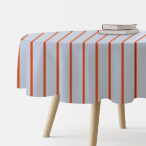 Okrągły obrus na stole z jasnoniebieskim tłem i pionowymi pomarańczowymi pasami