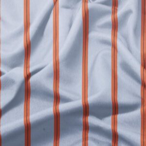 Zbliżenie na tkaninę i wyraziste pomarańczowe pasy na jasnoniebieskim tle